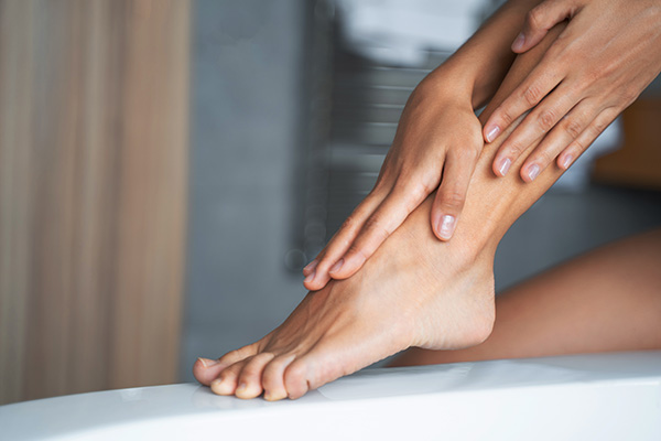 Woman applying a moisturizer on her legs